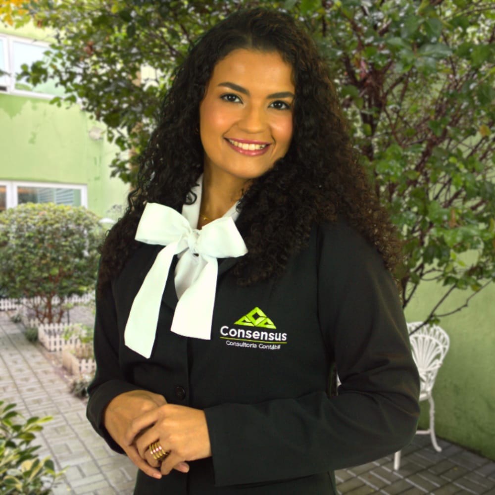 Moça sorrindo com um lindo jardim ao fundo.